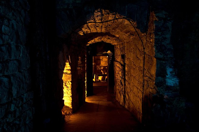 City of the Dead Underground Vaults (Day) - Inside the tunnels: lantern light, ghost stories, and families’ misery